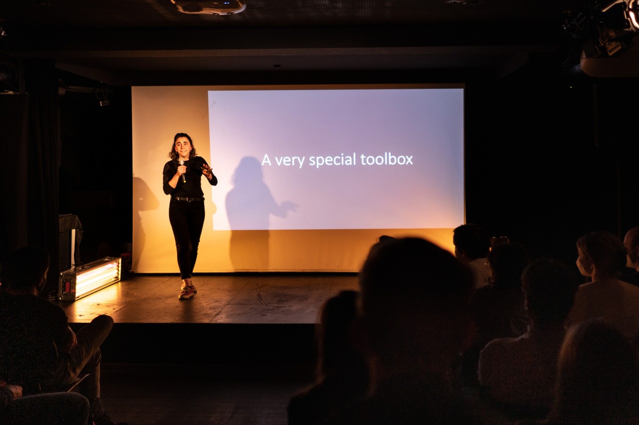 Female scientists on stage presenting a science slam in front of a audience.