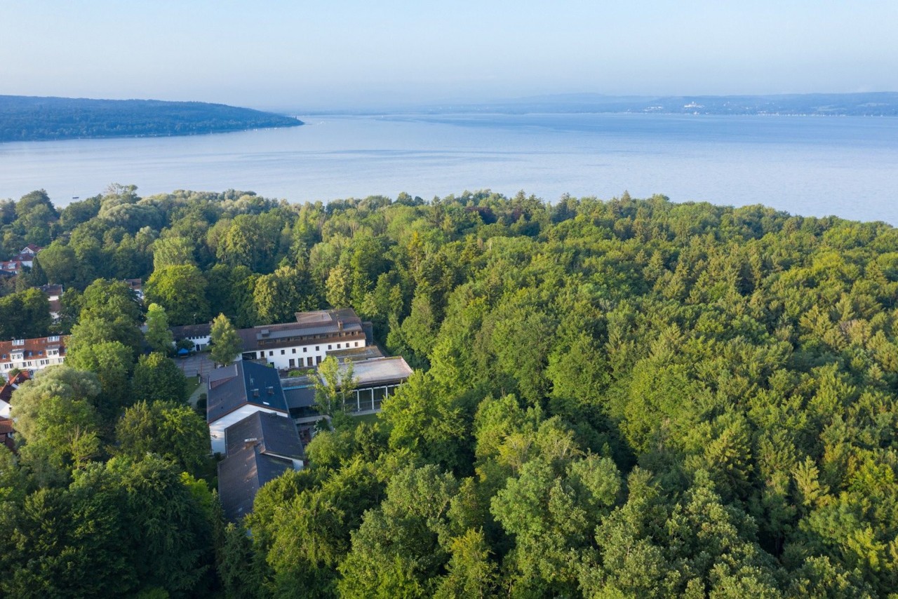 Aerial view of a event location surrounded by trees and the lake.