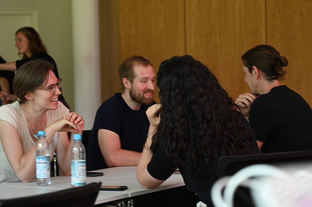 Students networking and discussing at tables. 