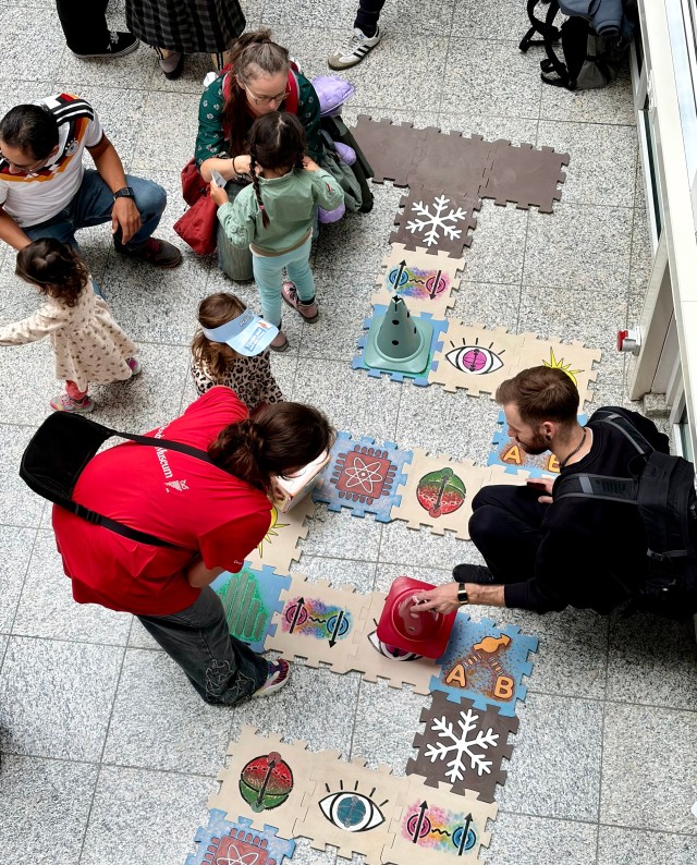 Visitors playing a game to learn quantum physics basics on the floor. 