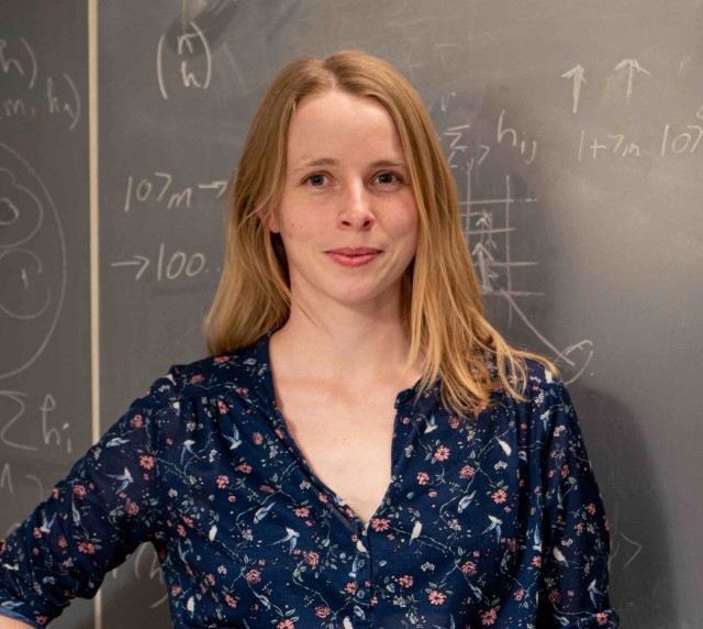Annabelle Bohrdt standing in front of a blackboard with mathematical formulas.