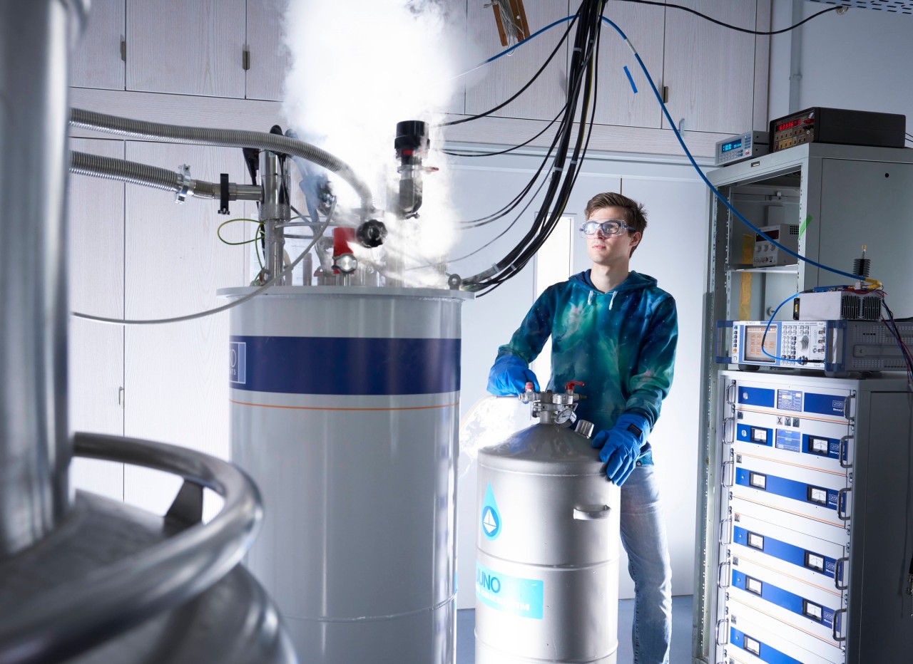 Young scientists opening a cyostat in a quantum lab. 