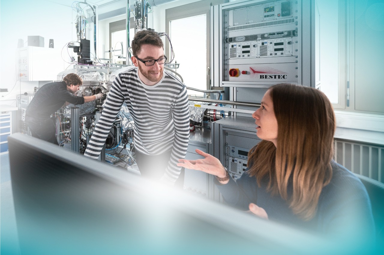 Young scientists working and discussing in a quantum laboratory. 