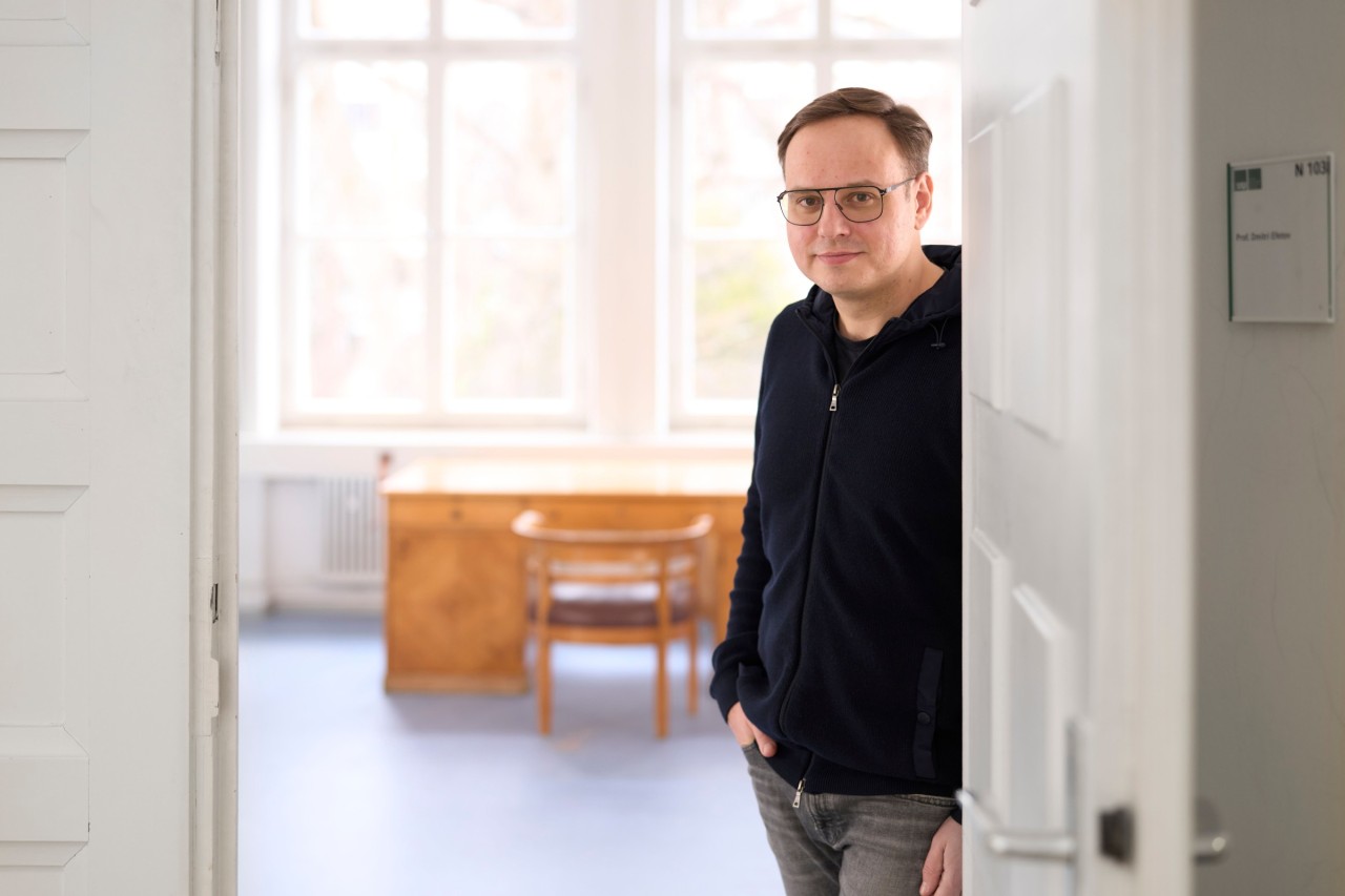 Prof. Dmitri Efetov leaning against the frame of his office door. 
