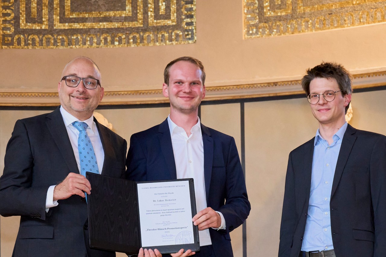 Lukas Homeier (center) being presented with his award by the Dean of the Faculty of Physics, Prof. Ulrich Schollwöck, together with his supervisor, Prof. Fabian Grusdt.