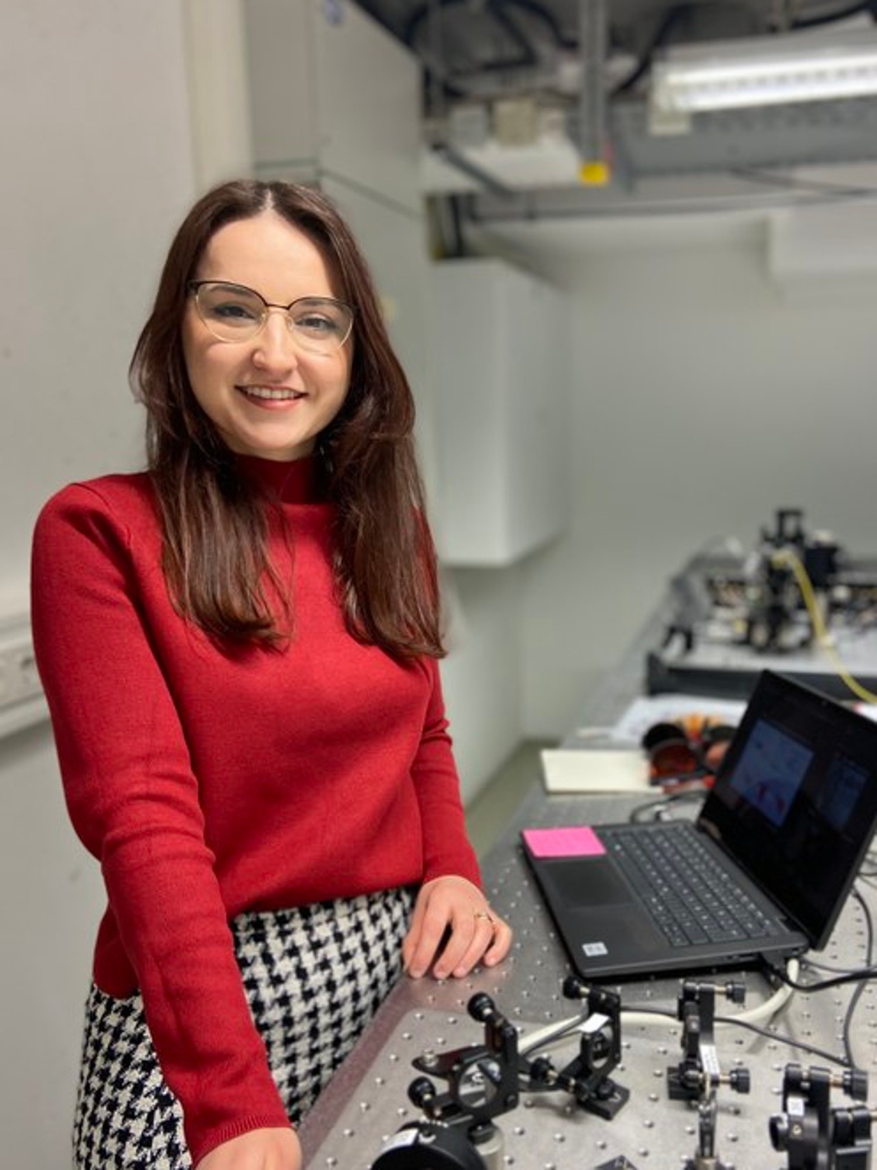 Linda Qerimi standing next to a table in the students laboratory. 