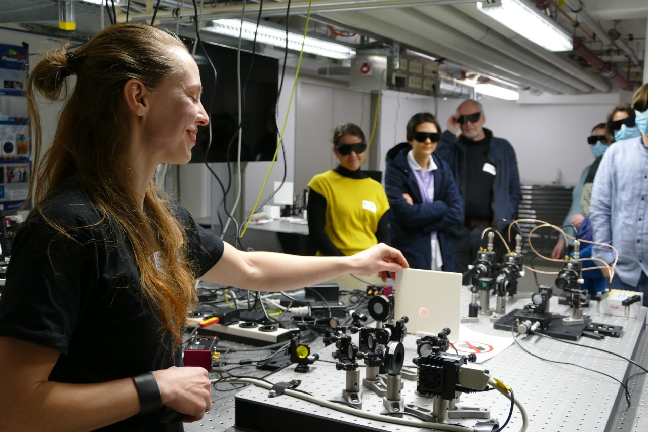Female scientists explaining an experimnet to school children. 
