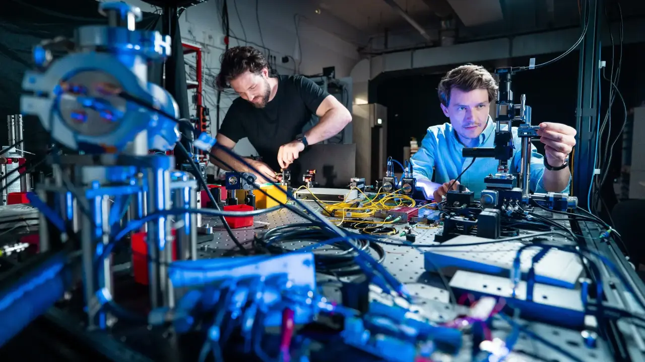 Stephan Rinner and Florian Burger are working on a experimental setup, laser light is guided through optical fibers to a microscope, where the tiny structures can be visualized.
