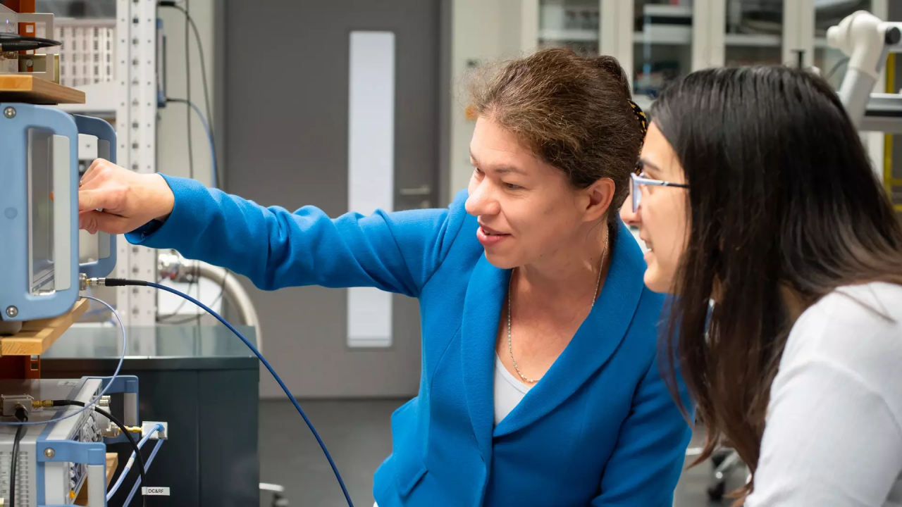 Eva Weig pointing to a device in her lab. 