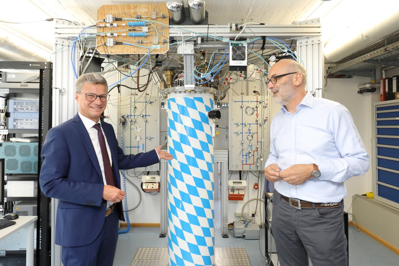 State Minister Sibler (left) and WMI director Rudolf Gross (right) in front of a real “Bavarian Quantum Machine”.