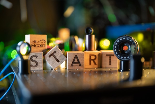 Wooden cubes with the letters START on an optical laser table top