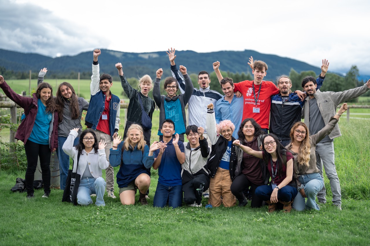 Group of students smiling and raising their hands up with joy. 